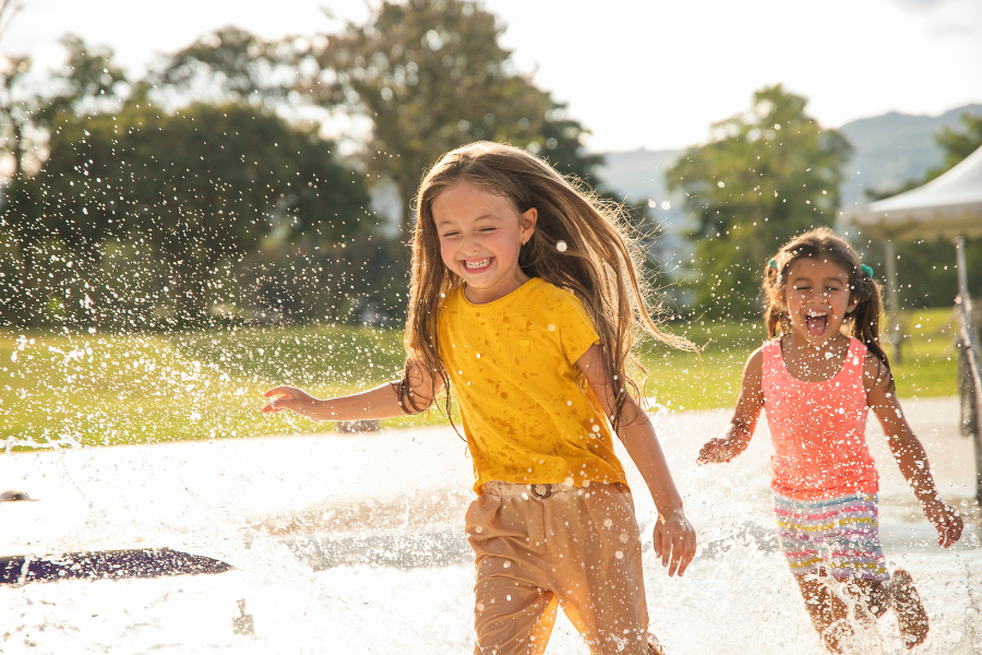 Kids playing in water outside smiling