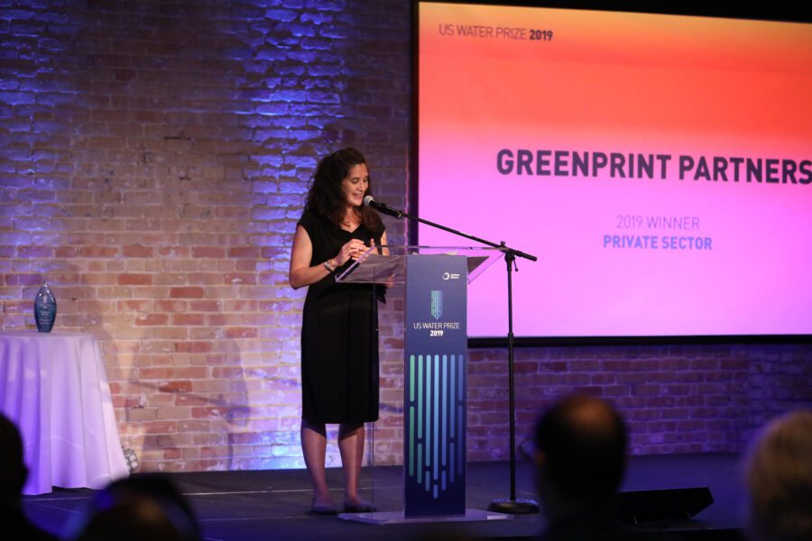 Woman stage brick wall podium gradient PowerPoint slide green to orange