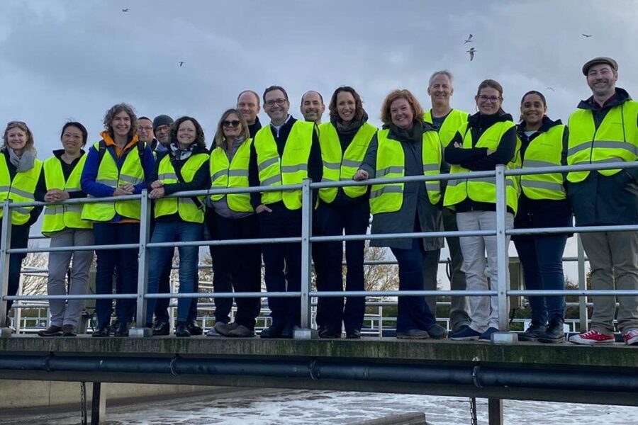 Utility members at water treatment plant in yellow vests smiling group photo