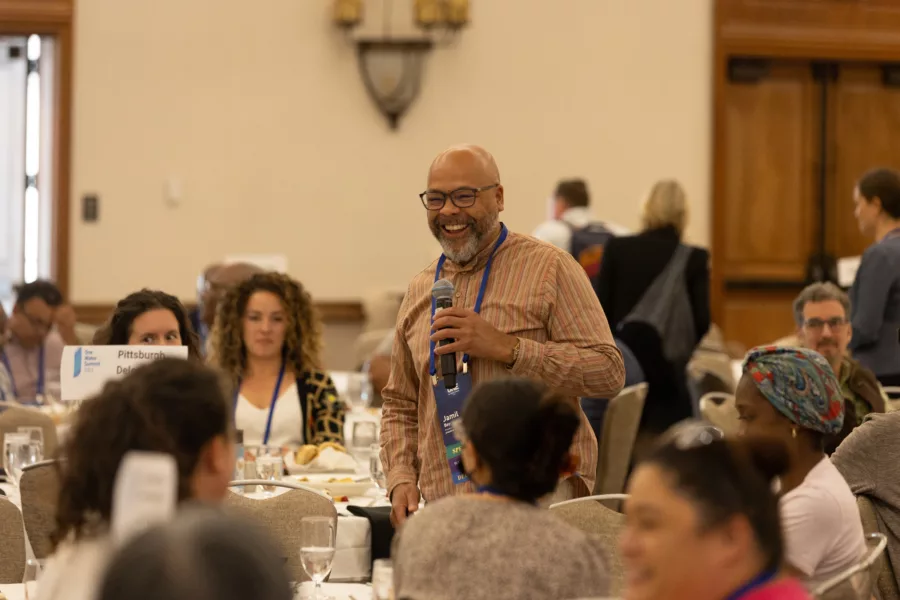 Man with microphone laughing conference inside