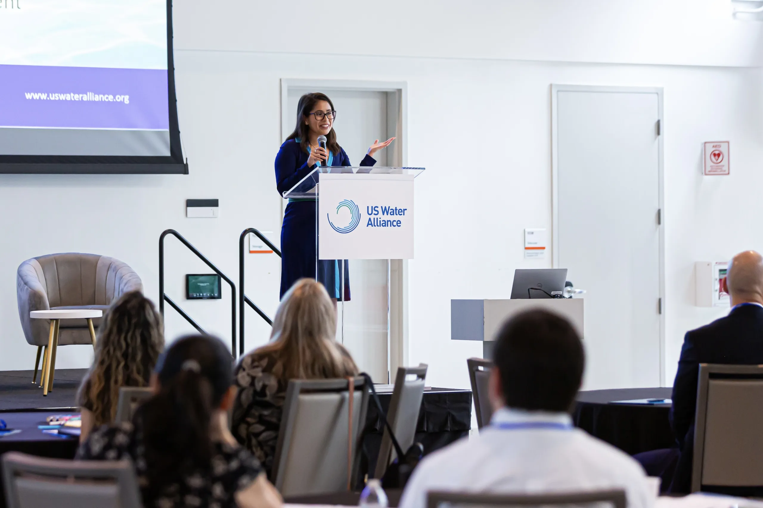 Woman speaking at conference onstage smiling daytime