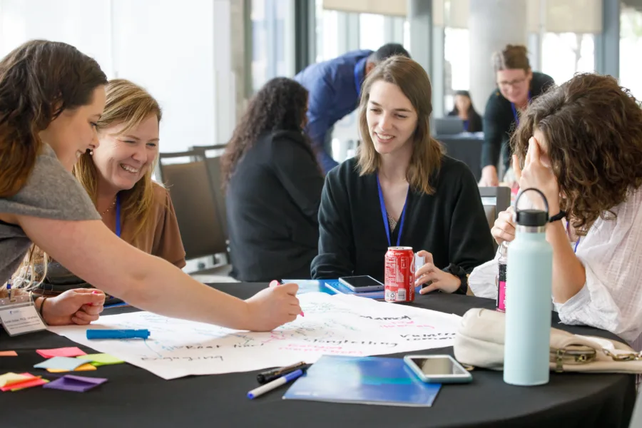Women working together smiling at table indoors