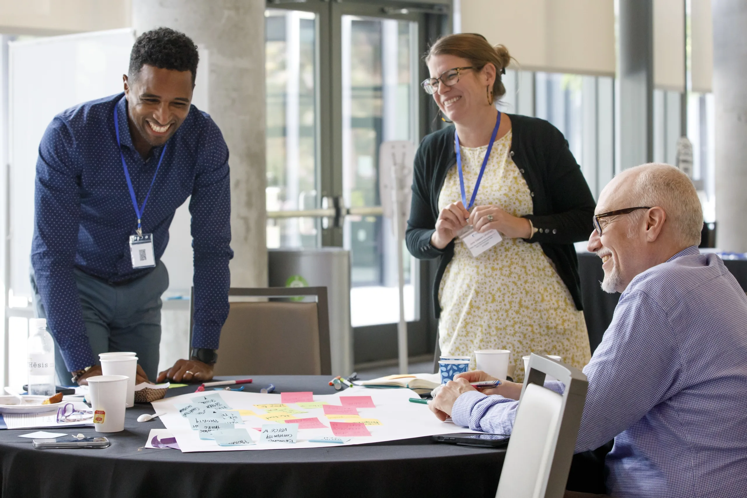 Three people at conference working together laughing