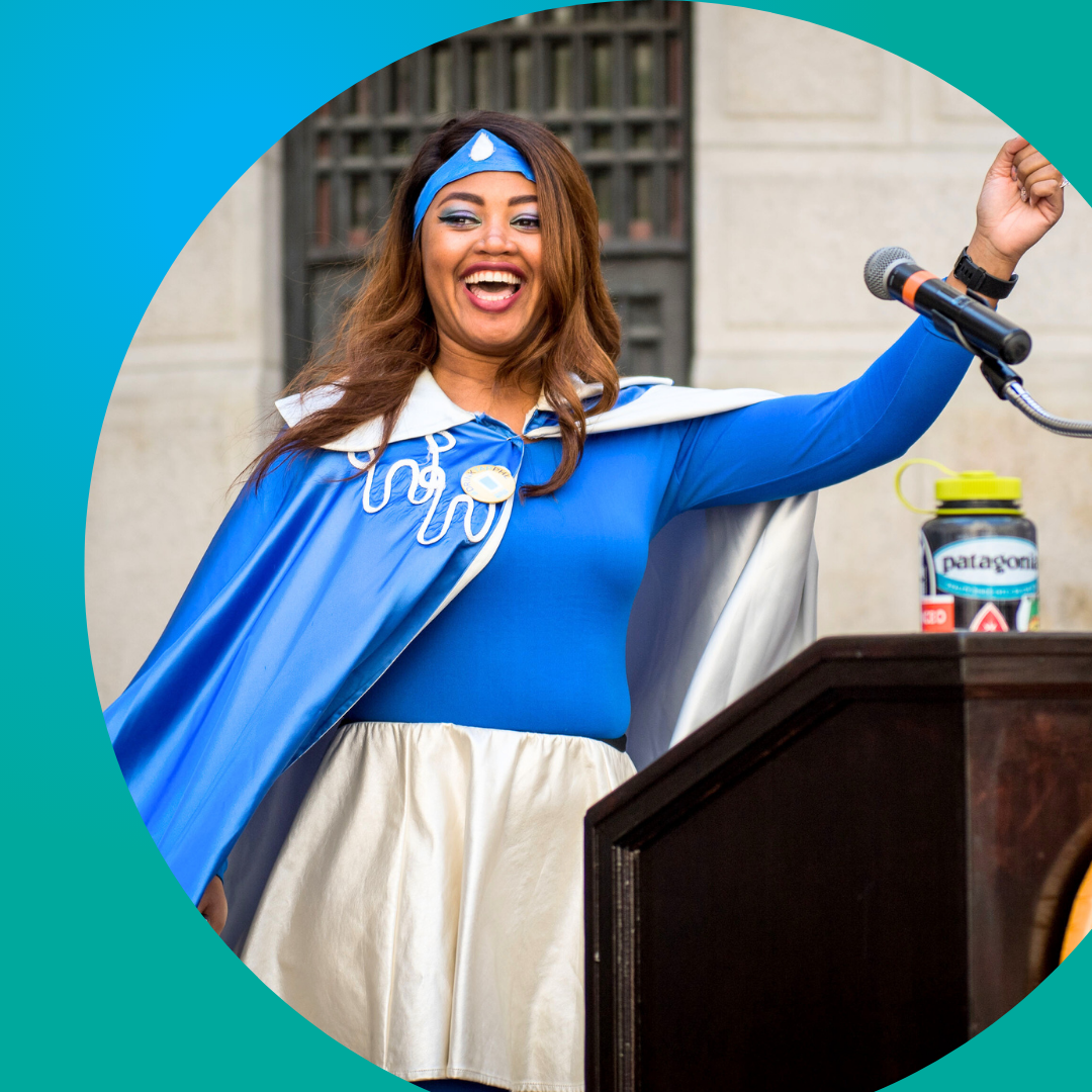 Superhero woman smiling at podium circular frame blue/green background