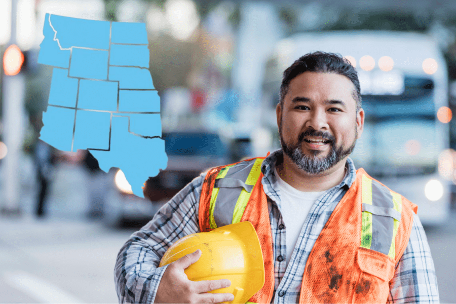 Utility worker smiling on street holding helmet with US mountain west map overlaid
