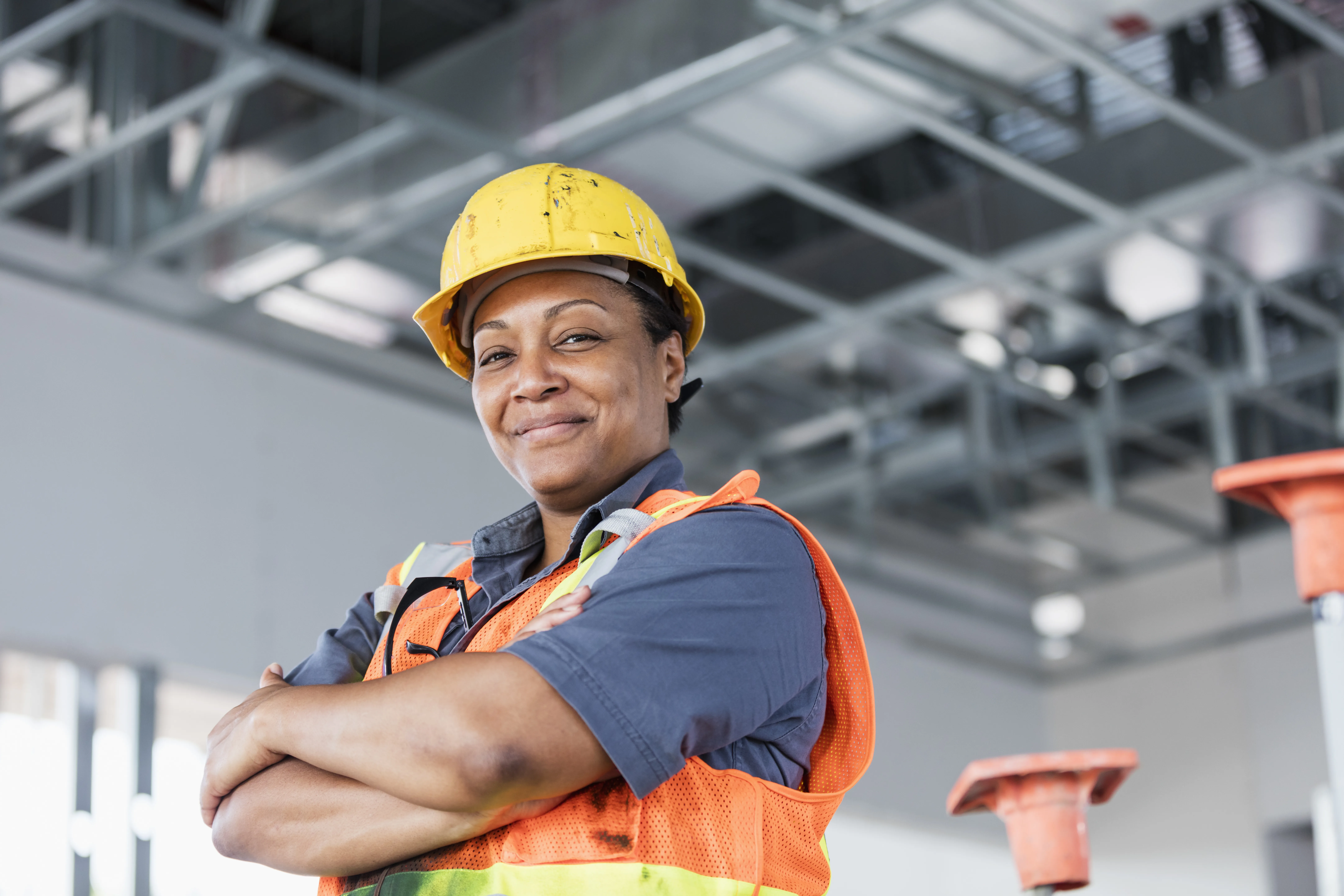 Woman in hard hat crossing arms and smiling