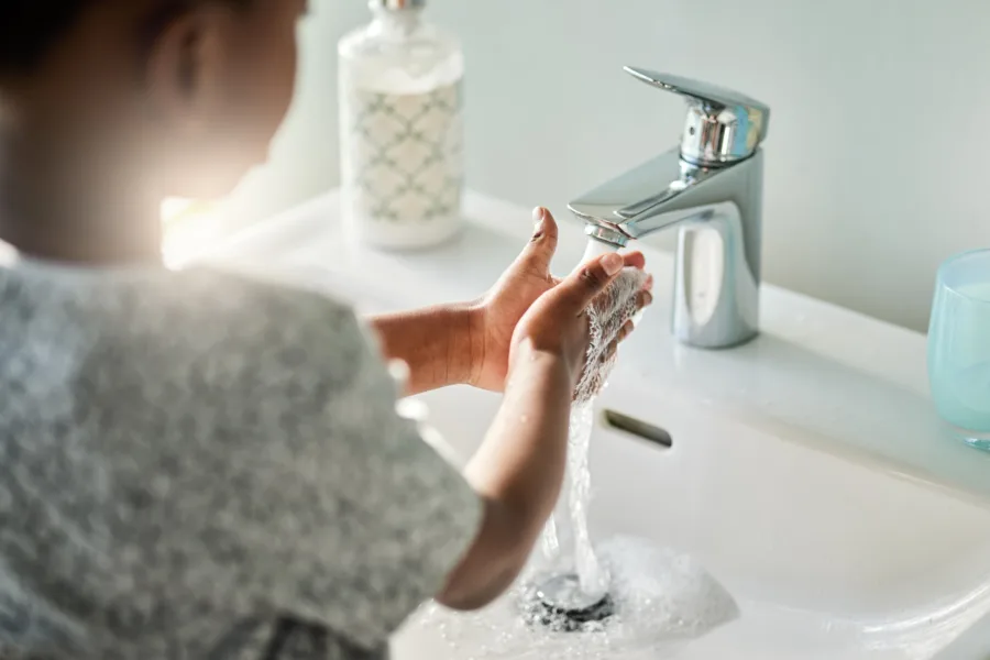Shot of child washing hands at sink
