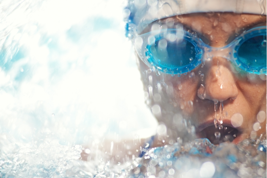 Person swimming close-up with goggles
