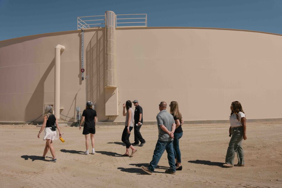 People walking around water tank in Joshua Tree, CA